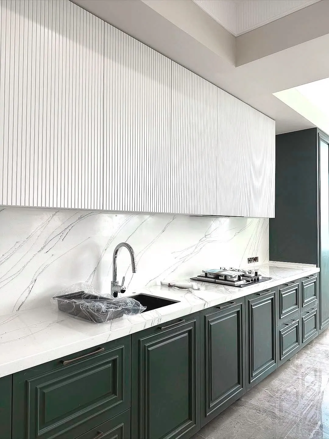 Kitchen by Gambini – fluted white wall units and marble splashback