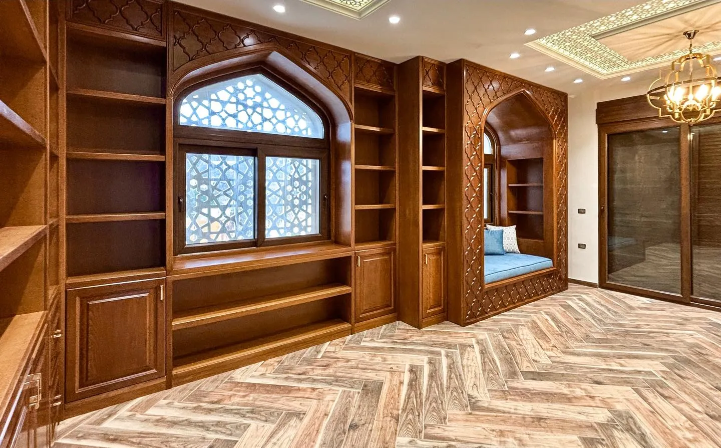 Traditional majlis by Gambini – wooden bookcases, arched niche and chandelier