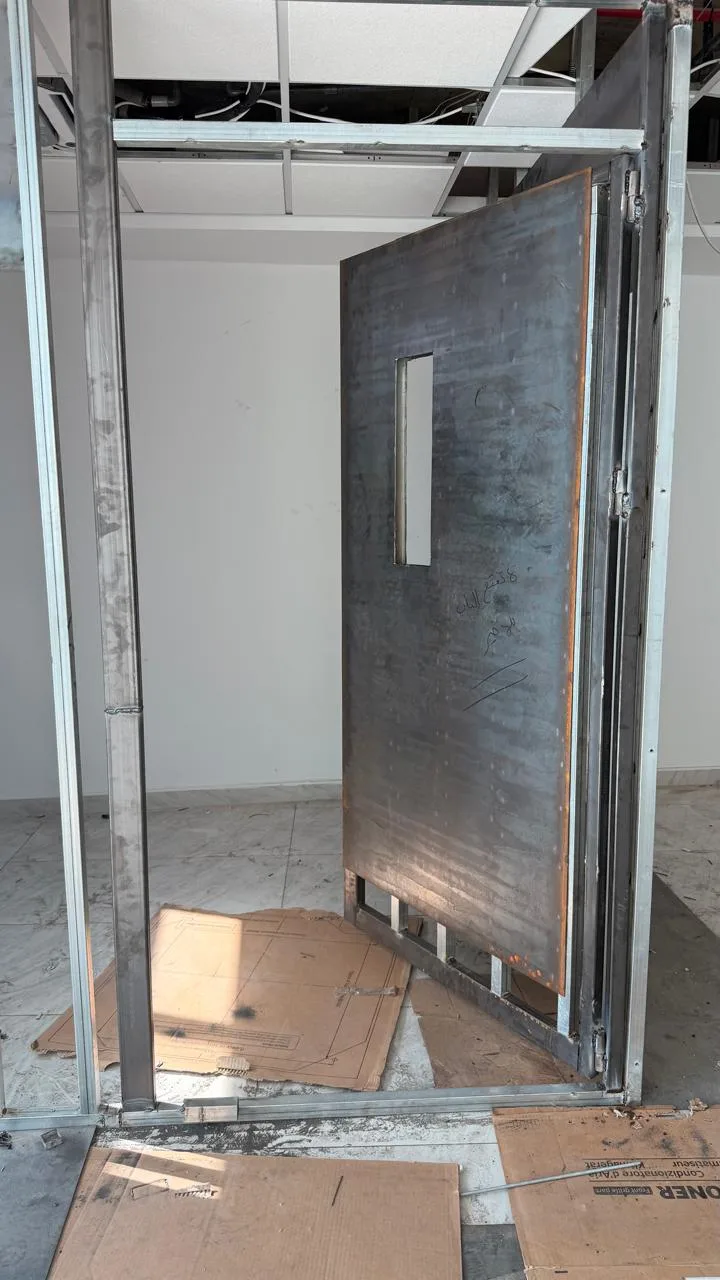 Heavy steel security door frame installed within metal stud partition
